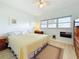 Well-lit bedroom featuring two windows, laminate flooring, and a ceiling fan at 7050 Sunset Way # 22, St Pete Beach, FL 33706