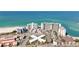 Expansive coastal view featuring multiple residential buildings, beach access, and tennis courts at 7050 Sunset Way # 22, St Pete Beach, FL 33706