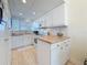 Clean, well-lit kitchen featuring white cabinets, appliances, and laminate flooring at 7050 Sunset Way # 22, St Pete Beach, FL 33706