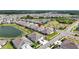 Beautiful aerial view of a well maintained neighborhood with a pond, mature trees, and manicured lawns at 7405 Stonebrook Cir, Wesley Chapel, FL 33545