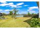 Expansive backyard with lush green grass and serene lake views with black metal fence at 7405 Stonebrook Cir, Wesley Chapel, FL 33545