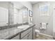 Bathroom featuring a granite countertop, grey cabinets, a large mirror, and two windows at 7405 Stonebrook Cir, Wesley Chapel, FL 33545