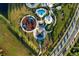 Aerial view showcasing playground, swimming pool, and pavilion in a planned community, surrounded by lush landscaping at 7405 Stonebrook Cir, Wesley Chapel, FL 33545