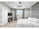 Spacious main bedroom featuring a large window, ceiling fan and decorative accent wall at 7405 Stonebrook Cir, Wesley Chapel, FL 33545