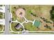 Overhead view of a neighborhood playground with mature trees, basketball court, and grassy space at 7405 Stonebrook Cir, Wesley Chapel, FL 33545