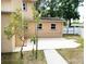 Rear exterior view of the home showcasing a concrete patio, landscaping and a white fence at 771 Murphy N Ave, St Petersburg, FL 33703