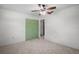 Cozy bedroom featuring neutral carpet, a ceiling fan, and a conveniently located closet with green doors at 771 Murphy N Ave, St Petersburg, FL 33703
