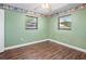 Bright bedroom featuring laminate flooring, painted green walls, and dual windows, creating a refreshing atmosphere at 771 Murphy N Ave, St Petersburg, FL 33703