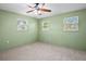 Bright bedroom with neutral carpet, a ceiling fan, and three windows that flood the room with natural light at 771 Murphy N Ave, St Petersburg, FL 33703