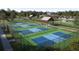 Aerial view of multiple pickleball courts with shaded gazebo and verdant green surroundings at 8566 Linked Dr, New Port Richey, FL 34655