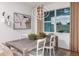 Bright dining room with a stylish table, seating for six, a modern chandelier, and a large window at 9950 Trellis Vine Way, Parrish, FL 34219