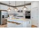 Modern kitchen with white cabinets, stainless steel appliances, a center island, and wood-finish barstool seating at 9950 Trellis Vine Way, Parrish, FL 34219