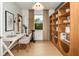 Bright office space features a white desk, exercise equipment, and custom built-in shelving unit at 9950 Trellis Vine Way, Parrish, FL 34219
