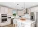 Bright kitchen featuring a center island, quartz countertops, stainless appliances and white cabinets at 9954 Trellis Vine Way, Parrish, FL 34219