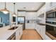 Stylish kitchen featuring stainless steel appliances, white cabinets, and a central island with sink at 9966 Trellis Vine Way, Parrish, FL 34219