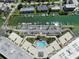 Aerial view of the property, showcasing a pool, parking, boat docks, and lush landscaping in a waterfront location at 1 Key Capri # 608E, Treasure Island, FL 33706