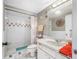 Bathroom featuring shower, vanity, and toilet with neutral tile and ample lighting at 1 Key Capri # 608E, Treasure Island, FL 33706