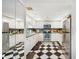 Retro kitchen design featuring black and white checkerboard floor, stainless appliances, and light wood cabinets at 1 Key Capri # 608E, Treasure Island, FL 33706