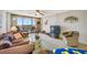 Spacious living room featuring a ceiling fan, comfortable seating, and a sliding glass door to a balcony at 1 Key Capri # 608E, Treasure Island, FL 33706