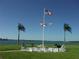 Outdoor recreation area with picnic tables, seating, palm trees and flags overlooking the beautiful water views at 1 Key Capri # 608E, Treasure Island, FL 33706