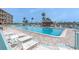 Inviting community pool with lounge chairs and lush tropical landscaping at 1 Key Capri # 608E, Treasure Island, FL 33706