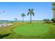 Community putting green for residents to enjoy, complete with palm trees, picnic tables and waterfront views at 1 Key Capri # 608E, Treasure Island, FL 33706