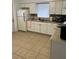Functional kitchen with white cabinets, tile flooring, and essential appliances at 1013 E Lake Ave, Tampa, FL 33605