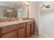 Bathroom featuring granite countertops, double sinks, a large mirror, and a glass-enclosed shower at 10144 Arbor Run Dr # 139, Tampa, FL 33647