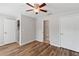 Cozy bedroom with wood-look floors, ceiling fan, and multiple closets at 10144 Arbor Run Dr # 139, Tampa, FL 33647