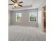 Spacious main bedroom with two windows, tray ceiling, and ensuite bathroom entrance at 10144 Arbor Run Dr # 139, Tampa, FL 33647