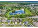 An aerial view of a residential community, highlighting the beautiful lake, golf course, and nearby homes at 10213 Lockwood Pines Ln, Tampa, FL 33635