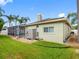 A lush backyard with a manicured lawn, a screened-in pool, and a view of the home's exterior at 10213 Lockwood Pines Ln, Tampa, FL 33635