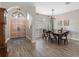 Inviting entryway and dining room with wood floors, an arched doorway, and modern chandelier at 10213 Lockwood Pines Ln, Tampa, FL 33635