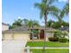 Charming single-story home with a well-manicured lawn and mature palm trees, creating an inviting curb appeal at 10213 Lockwood Pines Ln, Tampa, FL 33635