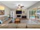 Comfortable living room with hardwood floors, a stone fireplace, and sliding doors to the pool area at 10213 Lockwood Pines Ln, Tampa, FL 33635