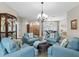 Spacious living room showcasing stylish blue chairs, an ottoman, and an elegant display cabinet with hardwood floors at 10213 Lockwood Pines Ln, Tampa, FL 33635