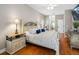 This main bedroom has wood floors, a ceiling fan, and a comfortable king-sized bed at 10213 Lockwood Pines Ln, Tampa, FL 33635
