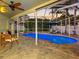 Inviting screened-in pool area with brick pavers, comfortable seating, and a clear view of the pool and landscaping at 10213 Lockwood Pines Ln, Tampa, FL 33635