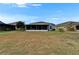 View of the home's back exterior featuring a large, dry lawn, and a screened-in back porch at 1040 Summer Breeze Dr, Brandon, FL 33511