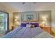 Cozy bedroom with wood floors, a ceiling fan, and views of the lush landscape at 1040 Summer Breeze Dr, Brandon, FL 33511