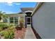 Charming entryway with colorful landscaping, a screened porch, and a stylish front door at 1040 Summer Breeze Dr, Brandon, FL 33511