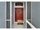Inviting front entryway with a decorative wreath on a red door, screened porch, and a 'Welcome' mat at 1040 Summer Breeze Dr, Brandon, FL 33511