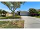 Charming home featuring a well-maintained lawn, mature trees, and an attached two-car garage at 1040 Summer Breeze Dr, Brandon, FL 33511