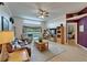 Spacious living room featuring an entertainment center, a piano, and sliding glass doors with pond views at 1040 Summer Breeze Dr, Brandon, FL 33511