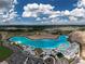 Stunning aerial view of community lagoon, showcasing its pristine turquoise waters and surrounding amenities under a sunny sky at 10446 Tupper Cay Dr, San Antonio, FL 33576