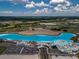 The aerial view showcases the expansive community lagoon with sandy beaches, amenities, and parking at 10446 Tupper Cay Dr, San Antonio, FL 33576