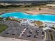 Panoramic aerial view of a community with a turquoise lagoon, parking, beaches, and recreational amenities at 10446 Tupper Cay Dr, San Antonio, FL 33576