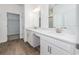 Bathroom featuring double vanity with white counters and wood look tile floors at 10446 Tupper Cay Dr, San Antonio, FL 33576