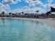 Picturesque community beach boasts white sand, turquoise water, and inviting lounge chairs under striped umbrellas at 10446 Tupper Cay Dr, San Antonio, FL 33576