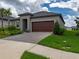 Charming single-story home featuring a tile roof, a brick paver driveway and lush landscaping at 10446 Tupper Cay Dr, San Antonio, FL 33576